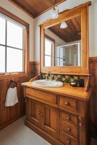 a bathroom with a sink and a mirror at Fernhem Cottages- Love in the Mist in Emerald