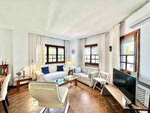 un soggiorno con un divano e una TV di Cabopino Port - EaW Homes a Marbella