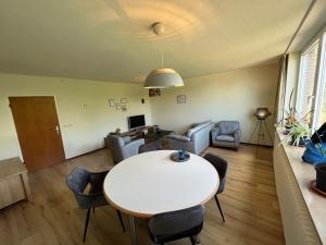 uma sala de estar com uma mesa branca e cadeiras em Dorfblick-Emsland em Rhede