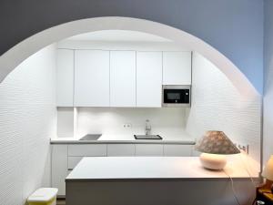 una cucina con armadi bianchi e un tavolo con lampada di Cabopino Port - EaW Homes a Marbella
