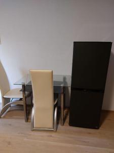 a dining room table with a chair and a refrigerator at Gemütliche Wohnung in Happenbach in Abstatt