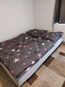 Una cama con una manta negra con estrellas. en Gemütliche Wohnung in Happenbach, en Abstatt