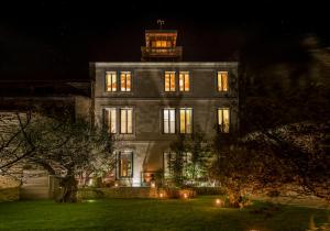 ein großes Gebäude mit beleuchteten Fenstern in der Nacht in der Unterkunft LE LANTERNON in Saint-Martin-de-Ré