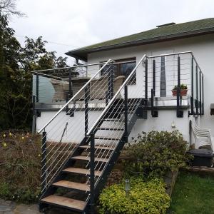 ein Haus mit einer Treppe, die auf einen Balkon führt in der Unterkunft Ferienhaus Fuxbau in Wohlau