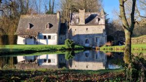 an old house with a pond in front of it at Moulin de Lossulien in Le Relecq-Kerhuon