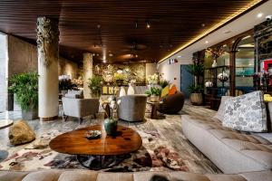 a lobby with a couch and tables and chairs at KunKin Garden Aparthotel in Ho Chi Minh City