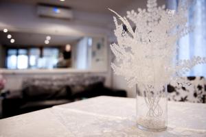 wazon wypełniony białymi kwiatami siedzącymi na stole w obiekcie Hotel Mirco w mieście Cattolica