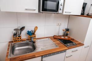 un comptoir de cuisine avec un évier et un micro-ondes dans l'établissement Central-Living blue - Netflix - WiFi, à Essen