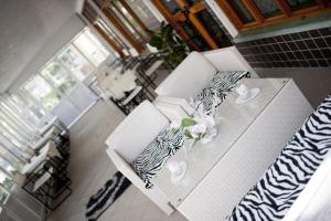 salon z 2 białymi krzesłami i stołem z kwiatami w obiekcie Hotel Mirco w mieście Cattolica