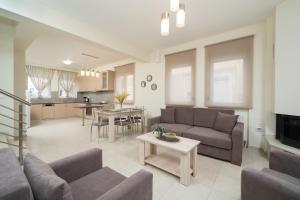 a living room with a couch and a table at Nik-Ntin Villa Deluxe in Prinos