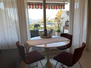 a dining room table with four chairs and a window at Studio centre Saint Tropez parking piscine wifi vue mer in Saint-Tropez