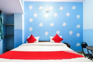 a blue bedroom with a bed with red pillows at OYO Hotel Moon Tara in Faridabad