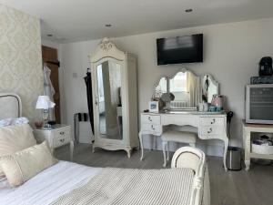 a bedroom with a bed and a vanity and a mirror at Coastal Joy - Room 4 in Newbiggin-by-the-Sea