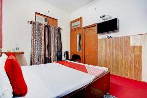 a bedroom with a bed and a flat screen tv at OYO Hotel Fridays in Bathinda