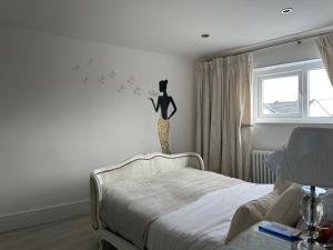 a bedroom with a bed and a statue of a cat on the wall at Coastal Joy - Room 4 in Newbiggin-by-the-Sea