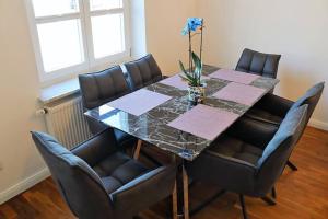 mesa de comedor con sillas y mesa de cristal en Ferienwohnung Parterre en Varel