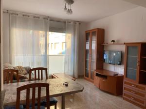 ein Wohnzimmer mit einem Tisch und einem TV in der Unterkunft Joan XXIII Apartment in Tarragona