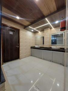 uma grande casa de banho com dois lavatórios e uma porta castanha em OYO Rajeswari Continental em Kanpur