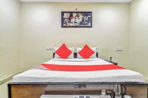 Bett in einem Zimmer mit roten Kissen darauf in der Unterkunft Hotel Airport Shine Inn in Shamshabad