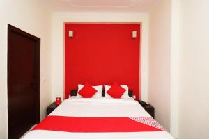 a bedroom with a bed with a red headboard at OYO Hotel Grand Casa Near Aravali Biodiversity Park in Gurgaon