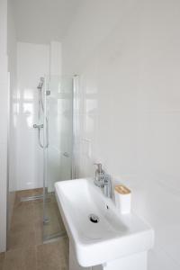 a white bathroom with a sink and a shower at ROKSOX-Home Meidling Schloss Schönbrunn in Vienna
