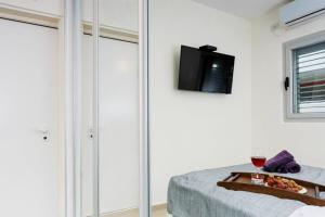 Cette chambre comprend un lit avec un plateau de fruits et une télévision. dans l'établissement Ben Yehuda Beach Appartment, à Tel Aviv