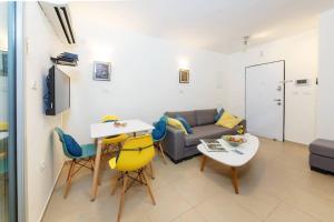 - un salon avec un canapé, une table et des chaises dans l'établissement Ben Yehuda Beach Appartment, à Tel Aviv
