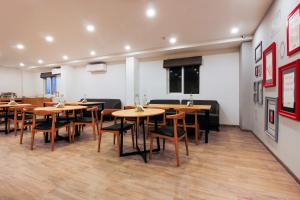 uma sala de jantar com mesas e cadeiras de madeira em Townhouse RCC Elite em Ameerpet