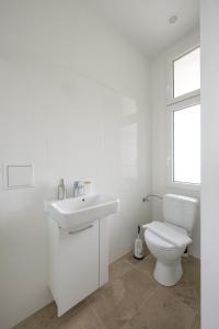 a white bathroom with a toilet and a sink at ROKSOX-Home Meidling Schloss Schönbrunn in Vienna