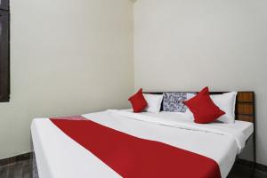 a bedroom with two beds with red and white pillows at OYO Samrat Residency in Faridabad