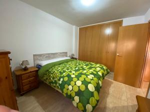 a bedroom with a bed and a wooden cabinet at Joan XXIII Apartment in Tarragona