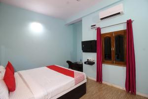 a hotel room with a bed and a television at Super Capital O Hotel Paradise Residency in Rāmnagar