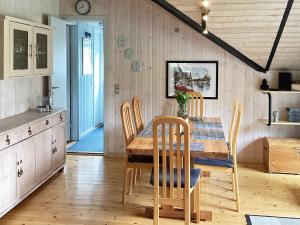 eine Küche und ein Esszimmer mit einem Holztisch und Stühlen in der Unterkunft 6 person holiday home in Ansager in Ansager