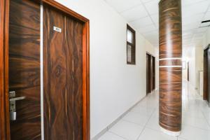 un corridoio con porta in legno in un edificio di OYO Hotel Rk Inn a Ludhiana