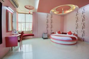 a bedroom with a large bed in a pink room at Super OYO Hotel Neelam in Amrāvati