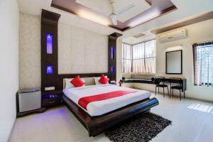 a bedroom with a large bed and a dining room at Super OYO Hotel Neelam in Amrāvati