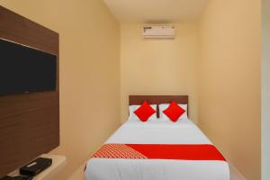 a bedroom with a bed with red pillows at OYO Jk Inn in Narasimharaja Puram