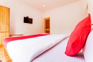 - une chambre avec un grand lit et des oreillers rouges dans l'établissement OYO Deluxe United Corporate Home, à Airoli