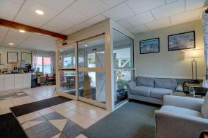 a living room with a couch and a kitchen at Quality Inn & Suites in Lincoln