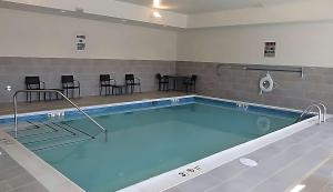 einen Pool mit Stühlen und einem Tisch in der Unterkunft Comfort Suites in Richmond