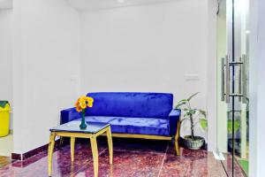 um sofá azul com uma mesa e um vaso com flores em Super Capital O The Jumar em Silwai
