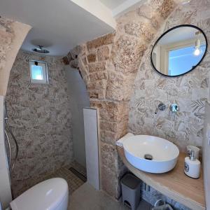 a bathroom with a sink and a mirror at Trullo in Light in Alberobello