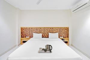 a bedroom with a white bed with a sewing machine on it at OYO Townhouse 691 Hotel Sulit in Tājganj