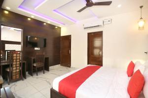 um quarto com uma cama, uma secretária e uma televisão em OYO Hotel Ska Hometel em Chandīgarh