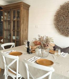 uma mesa de jantar com pratos e copos de vinho em Travellers Rest Bicheno em Bicheno