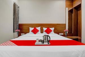 um quarto com uma cama branca e almofadas vermelhas em Flagship Hotel The Silver Nest em Nagpur