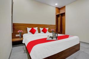 um quarto com uma cama grande e almofadas vermelhas em Flagship Hotel The Silver Nest em Nagpur