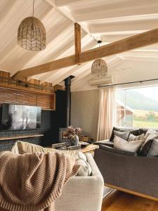 uma sala de estar com dois sofás e uma televisão em Travellers Rest Bicheno em Bicheno