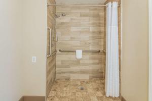 a bathroom with a shower with a shower curtain at MainStay Suites Columbus near Fort Benning in Columbus +21 photos