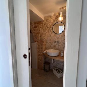bagno con lavandino e specchio di Trullo in Light ad Alberobello